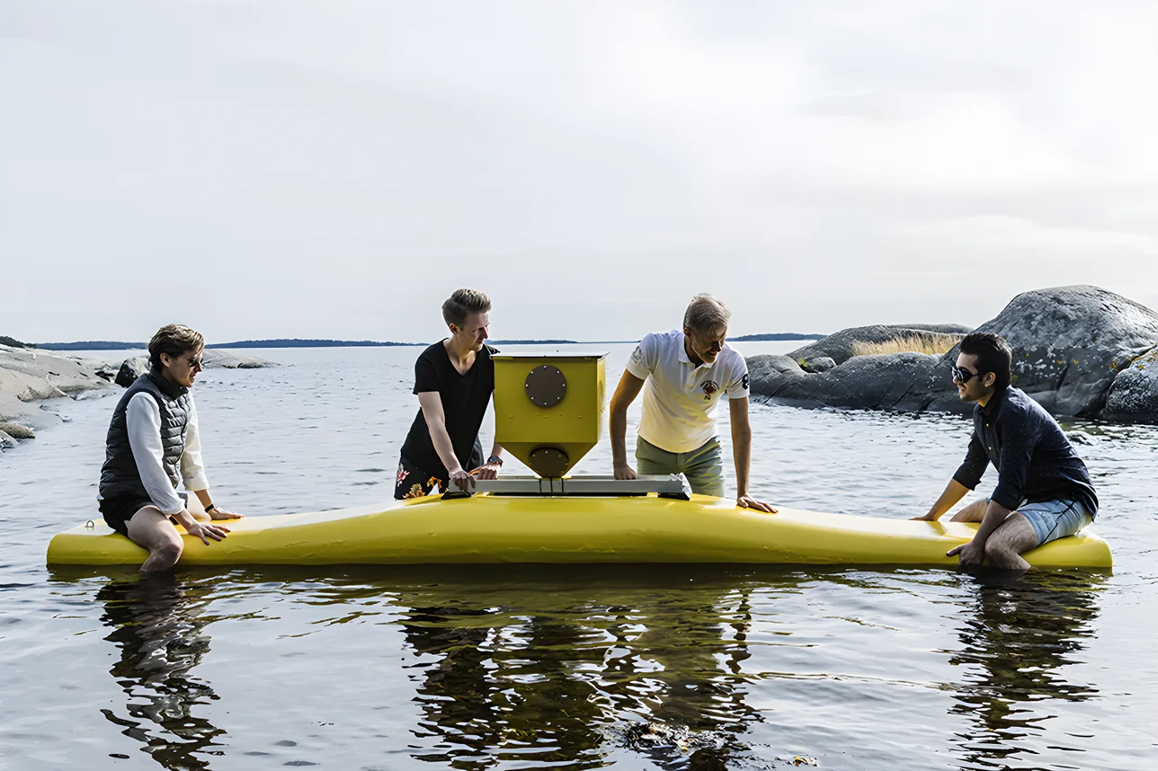 The NoviOcean team in the water around an early yellow wave energy float in the Swedish archipelago